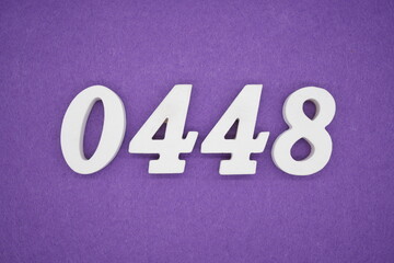 The numbers are made of white painted wood, placed on a purple paper background.