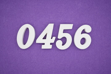 The numbers are made of white painted wood, placed on a purple paper background.