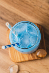 Milk is added to a glass of blue tea