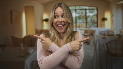 Woman pointing both index fingers outward in a cozy indoor restaurant setting; decision choice playfulness fun.