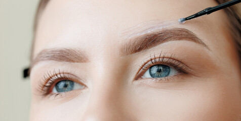Female caucasian young adult undergoing eyebrow tinting and correction wax technique