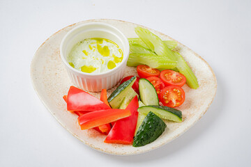 Colorful assortment of sliced vegetables and a creamy dressing awaits at a joyful summer event
