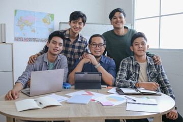 Five Smiling Young Men With Teacher Posing Smiling Confidently While Looking At Camera