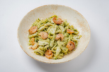Fresh pasta beautifully coated with vibrant pesto and topped with savory shrimp and cheese
