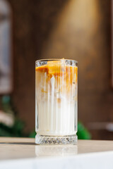 Iced latte in a clear glass with visible coffee and milk layers