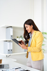 Asian business woman using digital tablet and laptop computer, working at office. internet technology
