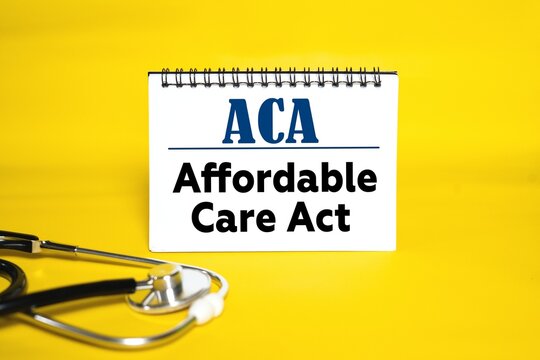 ACA - Affordable Care Act on a notebook. Doctor's stethoscope and bright yellow background.