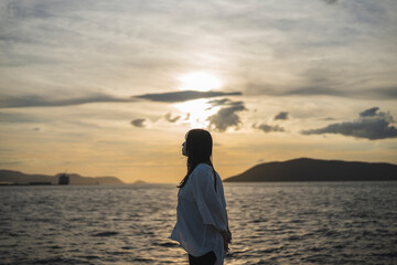 夕日の海にいる女性