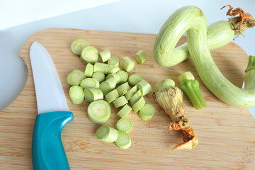 Zucchini sliced into unusual shapes on cutting board with ceramic knife. Healthy food and vegetables. Organic seasonal farm products.