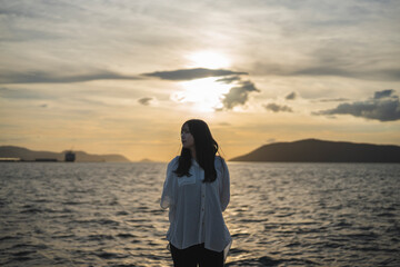 Fototapeta premium 夕日の海にいる女性