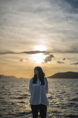 Fototapeta premium 夕日の海にいる女性