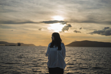 夕日の海にいる女性