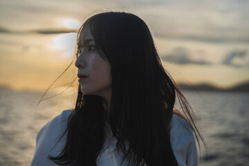 夕日の海にいる女性