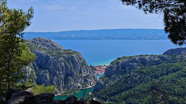Majestic panoramic view of Omis canyon and Adriatic sea framed by pine trees
