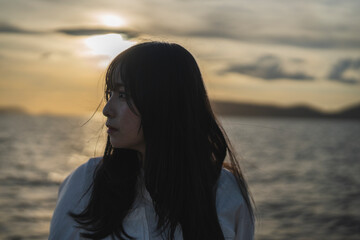 夕日の海にいる女性