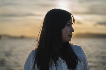 夕日の海にいる女性