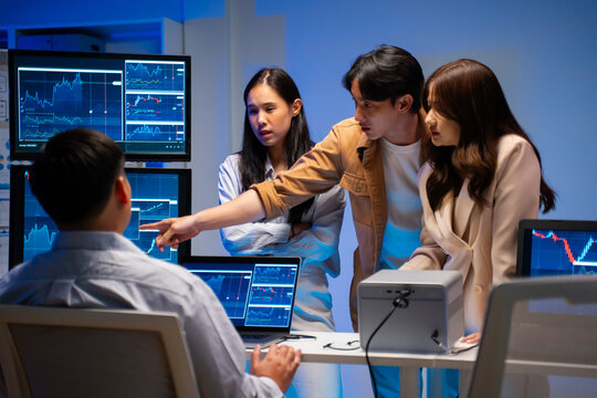 group of Happy young asian business people chatting happily after a night of overtime work in the office.Supervisor chats with employees after working together planning success strategy enjoy teamwork - Powered by Adobe