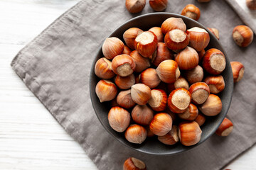Organic Raw Hazelnuts in a Bowl, top view. Space for text.