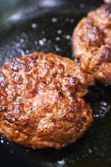 ハンバーグ - フライパンでハンバーグステーキを、ジュージュー音をさせながら焼く
