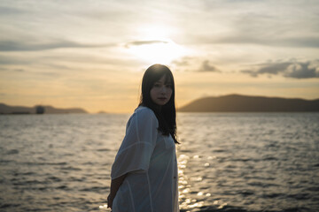 夕日の海にいる女性
