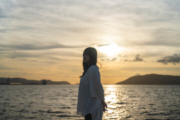 夕日の海にいる女性