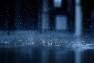 heavy raining make many small splash crown from water droplets drop down to the concrete floor in blue tone color scene
