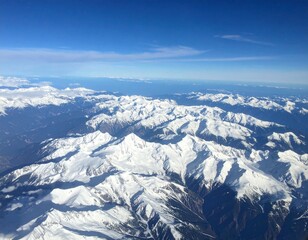 A breathtaking aerial view from an airplane window showcasing majestic snow-covered mountains with crisp white peaks