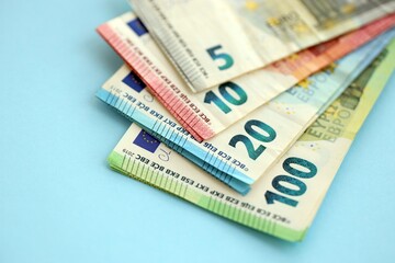Big amount of european euro currency money notes on blue color table close up
