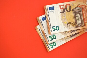 Big amount of european euro currency money notes on red color table close up