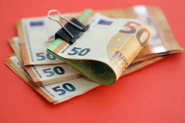 Big amount of european euro currency money notes on red color table close up