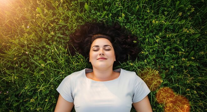 A beautiful photorealistic image of a plus-size woman lying in a field of green grass with a peaceful smile, enjoying the warm sun.