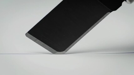 Metal cleaver slices into a white surface