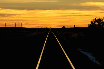 Train track rails glow in the sunset