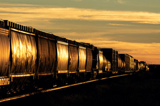 A freight train trailing off into the distance at sunset