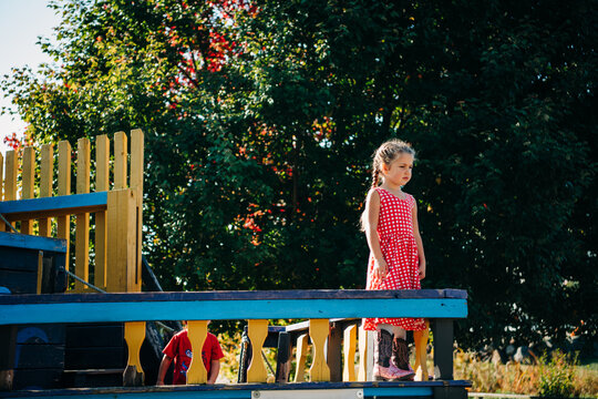 Little girl standing on a wooden pirate ship structure