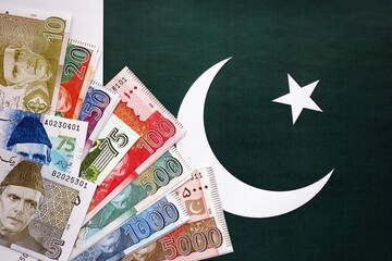 Pakistan rupees banknotes on Pakistani flag background. The current Pakistan money bills