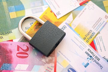 Swiss franc banknotes and padlock. The current francs money bills with lock lies in big amount