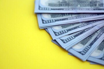 Big amount of United States hundred dollar bills on yellow background