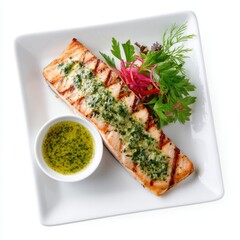 Grilled salmon fillet with green herb sauce, served on a rectangular white plate, isolated on white background