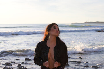 Portrait of Spanish woman, brunette with long hair and only black jacket posing for a photo shoot...