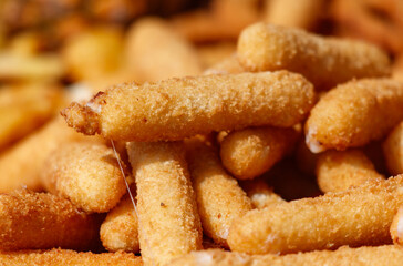 A pile of fried food with a few pieces of cheese on top