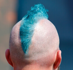 A man with a blue and green Mohawk