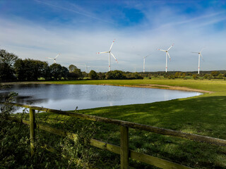 Pond and windmills, landscape near the Kiel canal in Schleswig-Holstein, Germany.