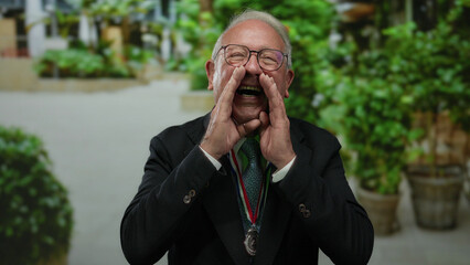 Senior man in business suit passionately speaking outdoors in a park with greenery in the...