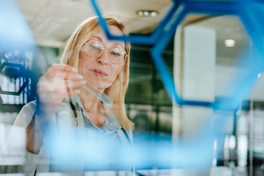 Scientist examining test tube with molecular lattice in laboratory