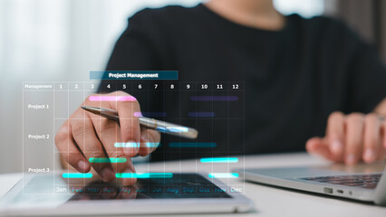 Close-up of hand using digital tablet and laptop with Gantt chart overlay. Concept of project management, planning, scheduling, team collaboration, time tracking, and business workflow visualization.