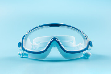 blue swimming goggles on blue background.