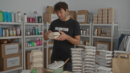 Man organizing food containers in donation room with shelves full of supplies in volunteer setting.