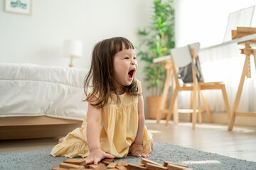 A cheerful young kid girl playing and running in cozy bedroom at home. 