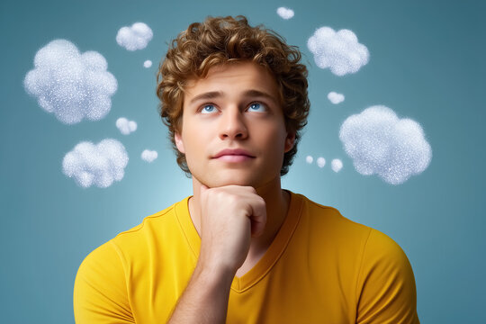 Young man with curly hair and yellow shirt looks up with a thoughtful expression, contemplating ideas represented by fluffy thought bubbles. Concept of creativity, inspiration, self-reflection